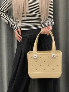 Close-up of beige EVA beach tote with perforated holes and durable handles