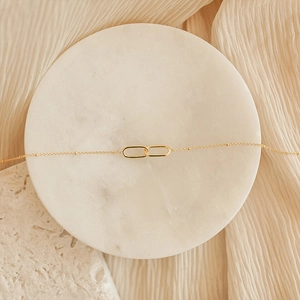 Minimalist gold-plated necklace with interlocking oval loops and tiny bead chain details