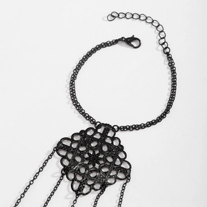 Macro detail of gothic matte black filigree hand chain with adjustable lobster clasp