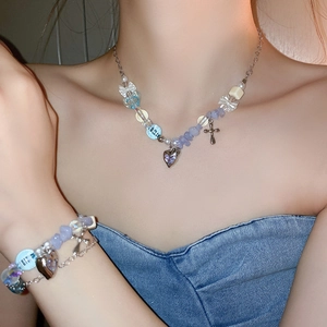 Detail view of Y2K heart and bow beaded necklace set on female model with blue denim outfit
