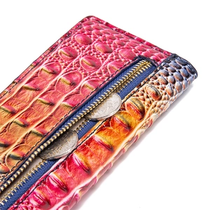 Macro view of crocodile embossed leather wallet with pink gradient and gold zipper