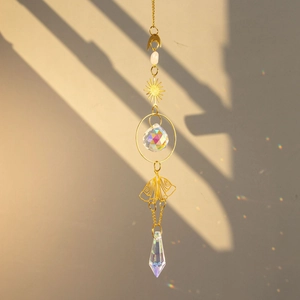 Brass butterfly suncatcher with raw crystals casting rainbow light on a warm beige wall