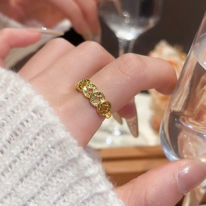 Detail view of 18k gold plated maple bow ring with hollow coin design on finger