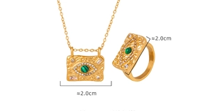 Detailed view of evil eye jewelry set with green stone on gold plated metal