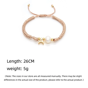 Detail of hand-woven bracelet featuring letter A charm and freshwater pearl with size info