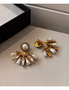 Vue macro de la boucle d'oreille éventail avec perle et détails en strass dorés