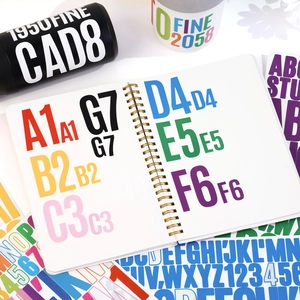 Detailed view of colorful waterproof vinyl letter stickers on a spiral notebook and water bottle
