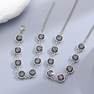 Close-up of square black gemstone necklace and bracelet set with silver-tone metal finish