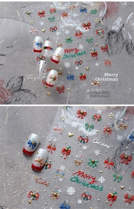 Detail of Christmas nail art stickers with snowflake and bow patterns in red and green colors