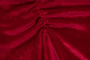 Vue macro détaillée du tissu en velours bordeaux avec des plis froncés et une texture douce