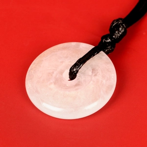 Detailed close-up of a pink jade Ping'an Kou pendant with a black adjustable cord