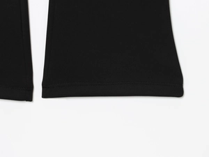 Detail of high-quality double-needle stitching on black flared pants or sweatshirt cuff