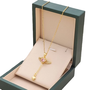 Golden Cupid angel wing necklace with pink heart pendant displayed in jewelry box