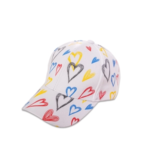 Detail of white cotton baseball cap showing vibrant multi-colored hand-drawn heart patterns