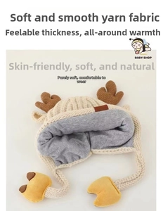 Detailed view of white knit baby winter hat with cute brown reindeer antlers and fleece lining