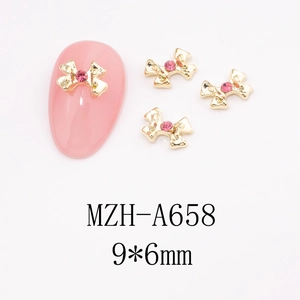 Detail of 9x6mm pink bow nail charms with gold metal base and sparkling rhinestones