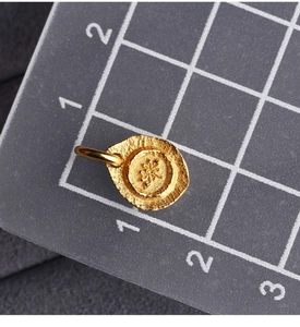 Macro shot of S925 gold-plated lotus tag with hammered texture and Chinese character