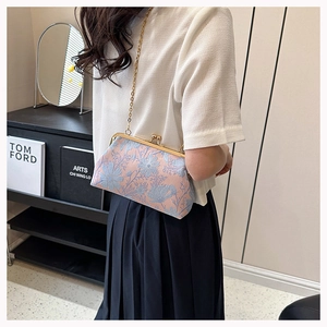 Detail view of vintage jacquard floral crossbody bag with gold chain and clasp closure