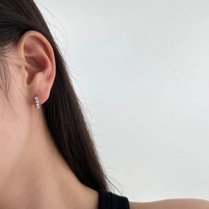 Detailed macro shot of S925 sterling silver earrings with three sparkling inlaid zircons