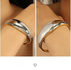 Detailed view of heavy two-tone gold and silver open cuff with a mirror finish