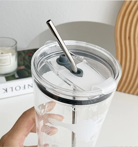 Close-up of high-capacity glass tumbler with world map print and stainless steel straw