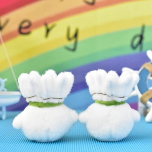Rear view of two cute white plush badminton shuttlecock pendants for bags and keys.