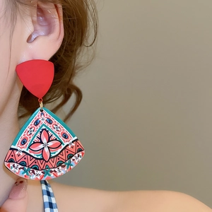 Detail of bohemian triangle drop earrings with colorful geometric floral pattern