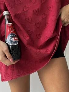 Vue détaillée de la texture gaufrée en forme de cœur sur un t-shirt en tricot rouge