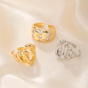 Irregular 18k gold and silver open rings with zircons on elegant silk background
