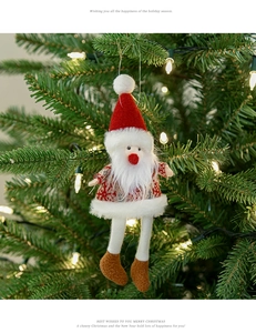 Dettaglio di un pupazzo di Babbo Natale appeso all'albero di Natale con luci calde