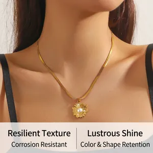 Detail of gold sunflower pendant with pearl on a sleek herringbone blade chain