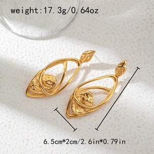 Detail of irregular hollow earrings with hammered gold texture and interlocking ovals