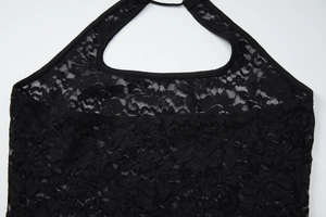 Détail de la dentelle florale sur un haut dos nu noir avec des finitions de bordure nettes
