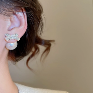 Close-up of bow knot pearl earrings with diamonds on a model for daily wear