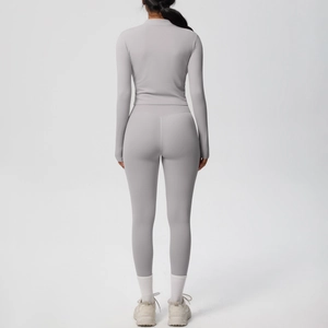 Vue arrière de l'ensemble de yoga gris clair avec legging de compression et manches longues