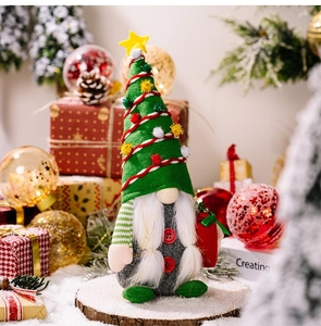 Detail of Christmas gnome with tree hat standing on snowy wood base among holiday decor