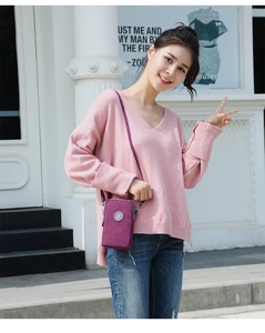 Mini sac à bandoulière violet en nylon porté par un mannequin en tenue décontractée