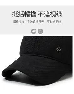 Detail of black winter baseball cap showing twill fabric texture and metal logo