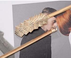 Détail d'une ceinture élastique dorée à ressort avec une boucle géométrique en éventail
