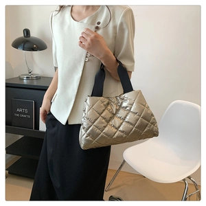 Détail du sac matelassé doré champagne avec effet métallisé et bandoulière noire