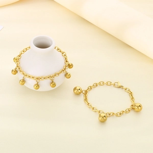 Minimalist 18K gold stainless steel beaded charm bracelet on a ceramic vase