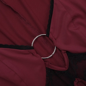 Close-up of burgundy fabric joined with black floral lace by a silver metal ring detail