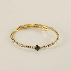 Detail of 18K gold-plated bangle with black square gem and paved white zircons
