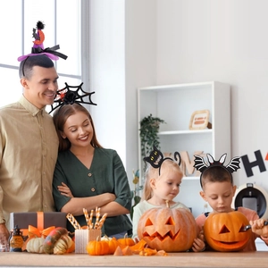 Family wearing Halloween headbands with spider, bat and pumpkin designs for a festive party