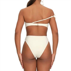 Detail of white one-shoulder swimsuit back with metal buckle and high-waist cut