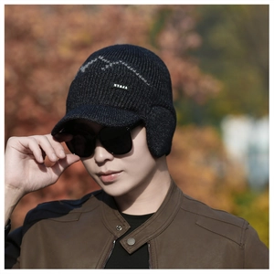 Detail of grey winter knit hat with ear flaps and branded label for cold protection