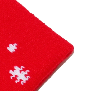 Close-up of red Christmas knit hat showing white snowflake patterns and texture