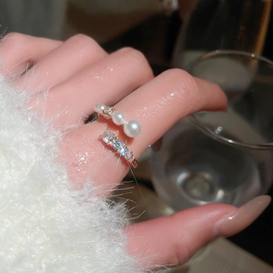 Close-up of gold plated ring featuring white pearls and rectangular cubic zirconia stones