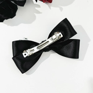 Detail view of the black satin bow hair clip with a durable metal spring fastener back