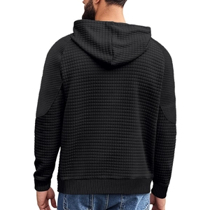 Detailansicht des schwarzen Herren-Kapuzenpullovers mit Waffelstruktur und Rippbündchen